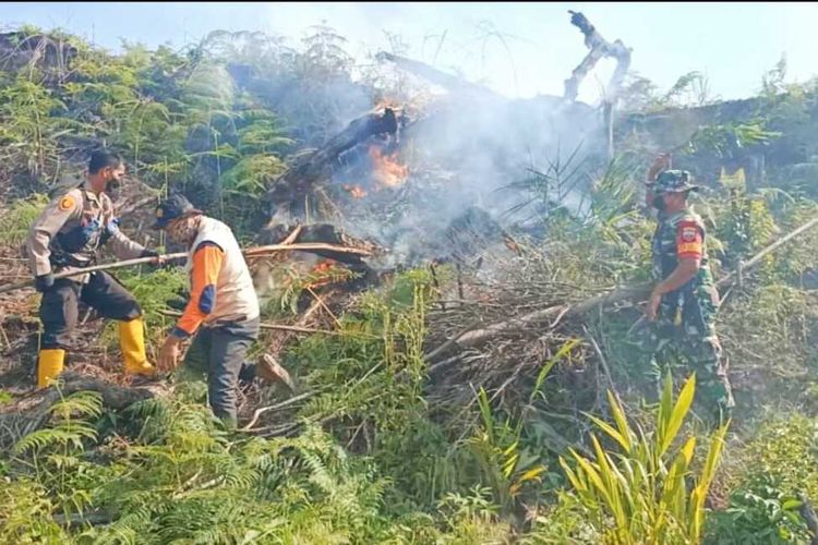 Petugas kepolisian, TNI dan BPBD Rohul memadamkan api karhutla menggunakan kayu di Desa Rambah Samo Barat, Kecamatan Rambah Samo, Kabupaten Rokan Hulu, Riau, Senin (28/3/2022).
