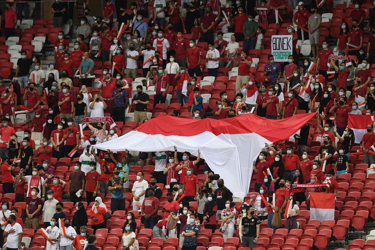 Suporter Timnas Indonesia memberikan sorakan dukungan pada pertandingan leg pertama final Piala AFF 2020 antara Indonesia vs Thailand di National Stadium, Singapura, Rabu (29/12/2021) malam WIB. Timnas Indonesia takluk 0-4 dari Thailand pada laga leg pertama final Piala AFF 2020.