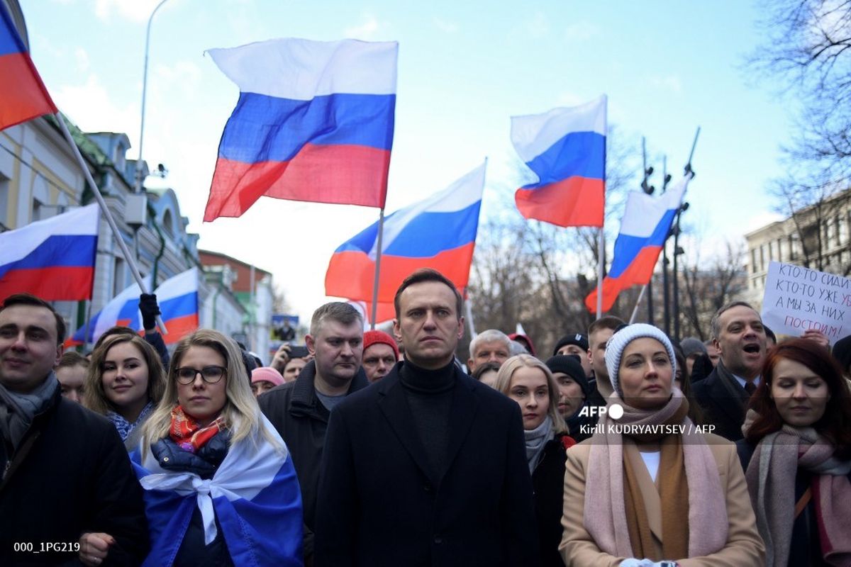 Pemimpin oposisi Rusia Alexei Navalny (tengah) bersama istrinya, Yulia, dan tokoh oposisi Lyubov Sobol, serta para demonstran saat mengenang tewasnya kritikus Kremlin, Boris Nemtsov, di Moskwa pada 29 Februari 2020.
