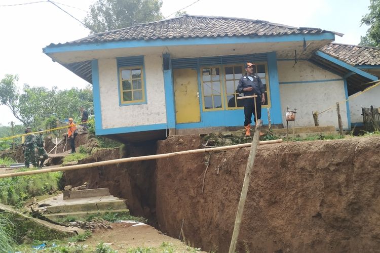 Seorang sukarelawan memantau rumah terdampak bencana tanah bergerak Dusun Suradita, Desa Cijangkar, Kecamatan Nyalindung, Sukabumi, Jawa Barat, Selasa (9/2/2021).