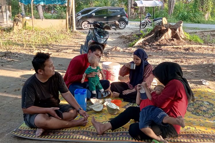 Satu keluarga dari Kota Pekanbaru menikmati buah durian yang baru jatuh dari batangnya, di Desa Pulau Birandang, Kecamatan Kampa, Kabupaten Kampar, Riau, Rabu (15/11/2023).