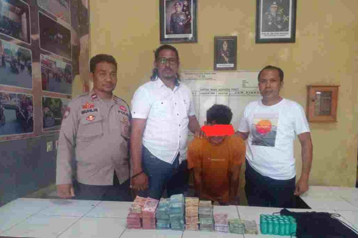 AB (25) saat diamankan di Mapolsek Woha bersama barang bukti uang hasil pencurian, Senin (3/7/2023).