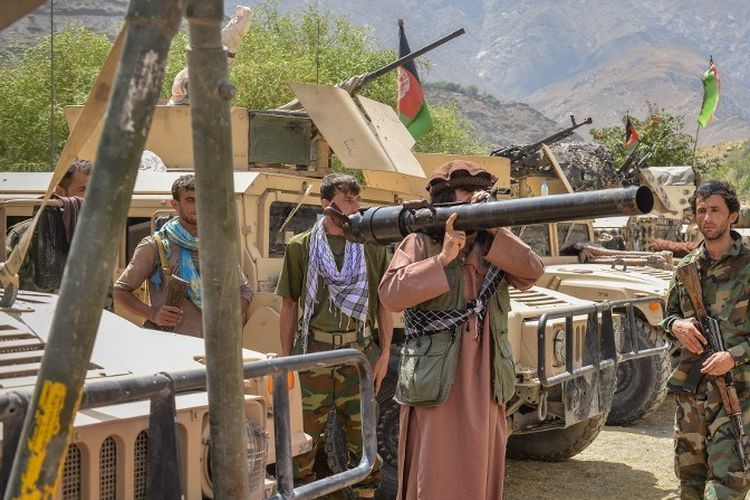 Seorang milisi berdiri bersama anggota pasukan pemerintah Afghanistan pada 19 Agustus 2021. Wakil Presiden Amrullah Saleh dan pemimpin milisi lokal Ahmad Massoud dilaporkan membentuk kembali kelompok perlawanan terhadap Taliban di Lembah Panjshir.