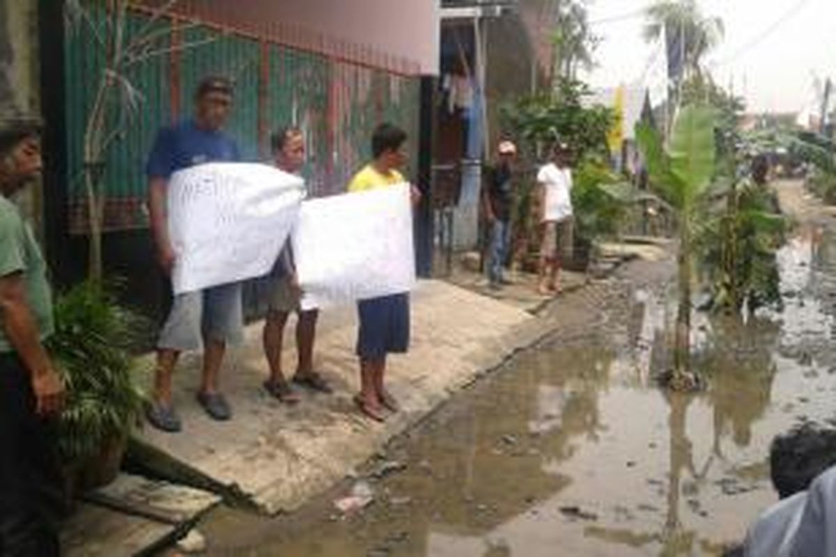 Warga Semper Barat, Cilincing, Jakarta Utara, Selasa (18/3/2014), memblokir jalan rusak dengan pohon pisang sebagai tanda protes Pemprov DKI Jakarta tak juga memberesi jalan rusak itu sejak 2009.