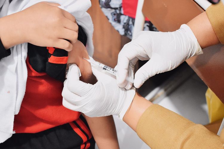 Penyuntikkan vaksinasi terhadap siswa dalam program bulan imunisasi anak nasional (BIAN).