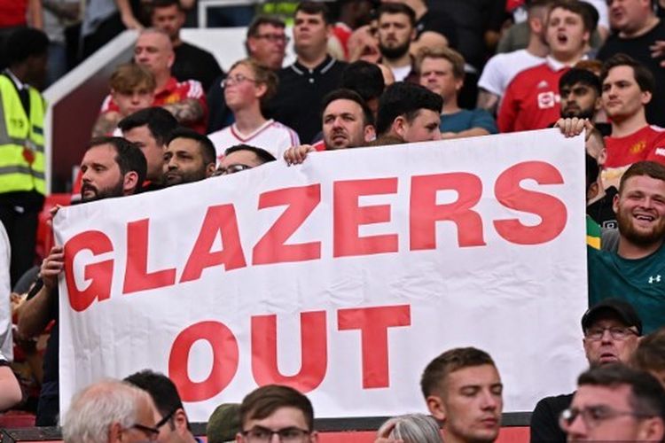 Fan Man United membentangkan spanduk 'Glazers Out' saat laga Man United vs Arsenal dalam lanjutan Liga Inggris di Stadion Old Trafford pada 4 Septemberr 2022. (Foto oleh Oli SCARFF / AFP) 