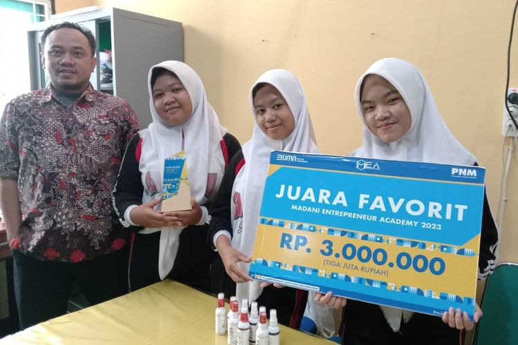 Siswi SMKN 1 Jombang, Jawa Timur, Rimbi Lenggani, Nurul Nur Hidayah dan Arvia Nabila Tri Agustin, bersama Ketua Jurusan Akuntansi Hafis Muaddab, menunjukkan penghargaan dari ajang MEA 2023 yang diperoleh berkat produk deodorant ramah lingkungan yang mereka ciptakan.