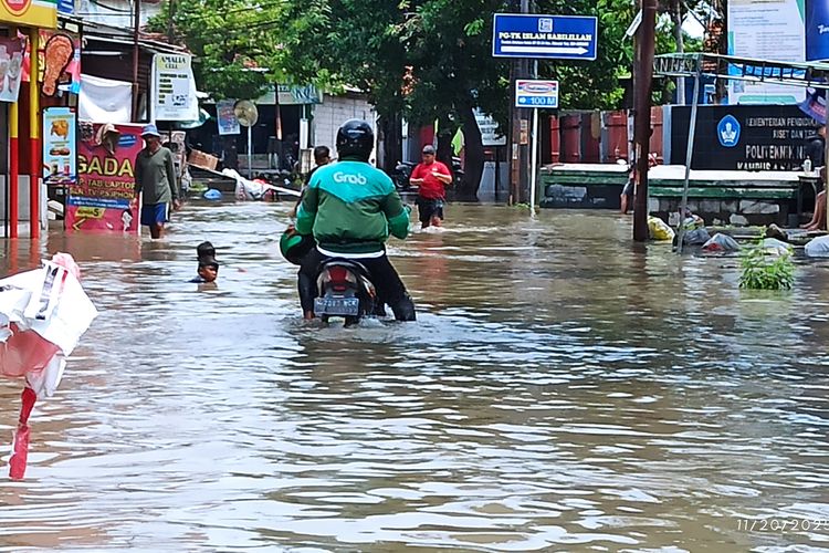 Seorang pengemudi ojol di Sidoarjo nekat terobos banjir demi antar pesanan warga yang kebanjiran, Kamis (20/11/2025).