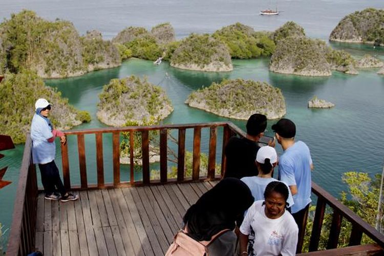 Wisatawan menikmati pemandangan gugusan pulau karst dari Bukit Piaynemo, Desa Pam, Kecamatan Waigeo Barat Kepulauan, Kabupaten Raja Ampat, Papua Barat, Senin (31/11/2016).