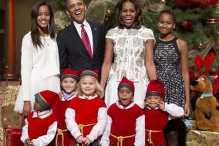 (Dari kiri ke kanan) Malia, Presiden Barack Obama, Michelle Obama, dan Sasha, bersama pasien anak-anak Children's National Medical Center dalam perayaan Natal di National Building Museum di Washington, Minggu (15/12/2013). 

