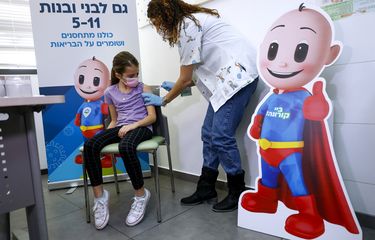 Danae Vitkin (9) disuntik dosis pertama vaksin Covid-19 Pfizer di Clalit Health, Tel Aviv, Israel, Selasa (23/11/2021). Israel mulai hari itu memvaksinasi anak-anak usia 5-11 tahun.
