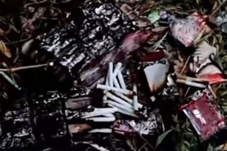 Ratusan batang rokok yang ditemukan dari dalam bus dikeluarkan oleh petugas saat proses pemadaman api, Minggu (1/6/2025). 