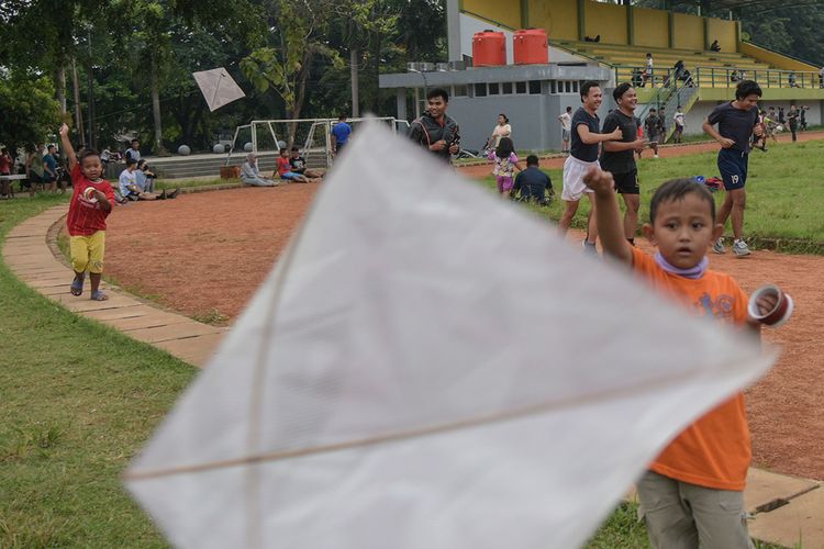 Sejumlah anak bermain layang-layang dan warga mulai beraktivitas olah raga di Lapangan Serbaguna kota Bekasi, Jawa Barat, Kamis (28/5/2020). Pemkot Bekasi akan segera memberlakukan tatanan normal baru pada bulan Juni mendatang.