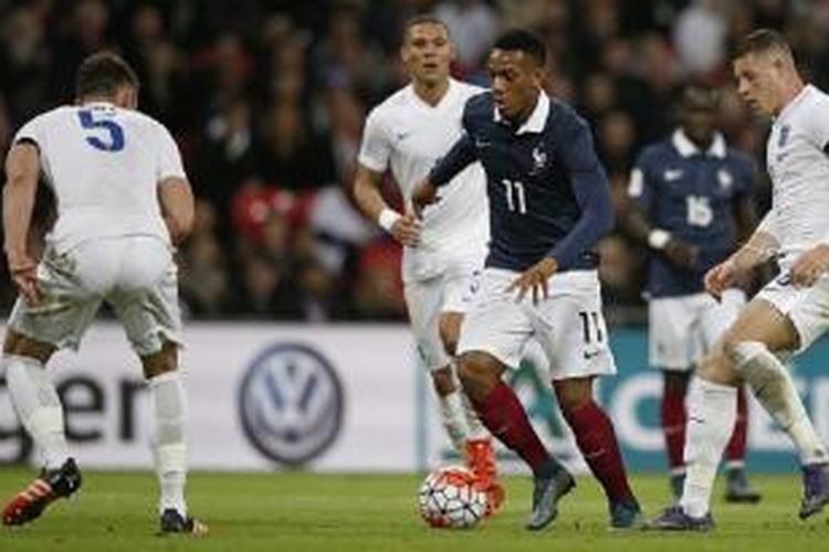 Penyerang Perancis, Anthony Martial (tengah), menggiring bola di antara para pemain Inggris pada laga uji coba di Stadion Wembley, London, Selasa (17/11/2015) waktu setempat.