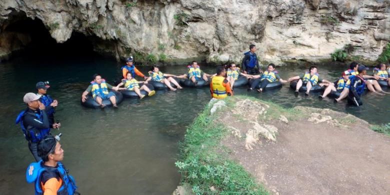 Wisatawan menggunakan ban sebagai pelampung menyusuri Gua Pindul, sebuah gua sepanjang 300 meter dengan sungai yang mengalir di dalamnya, sebagai bagian dari wisata yang ditawarkan oleh Desa Wisata Bejiharjo, Kecamatan Karangmojo, Kabupaten Gunungkidul, Kamis (22/11/2012). Wisata yang mulai beroperasi sejak tahun 2010 ini berhasil menggerakkan ekonomi warga setempat dari mata pencaharian semula sebagai petani ke bidang jasa.