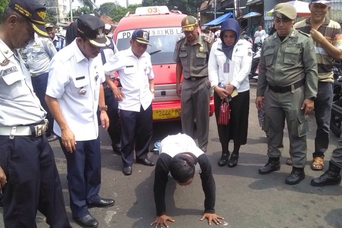 Soni (25) sopir angkot S03 Pondok Labu-Kebayoran Lama dihukum push up karena tidak memakai seragam saat beroperasi di Pasar Kebayoran Lama, Rabu (5/7/2017).