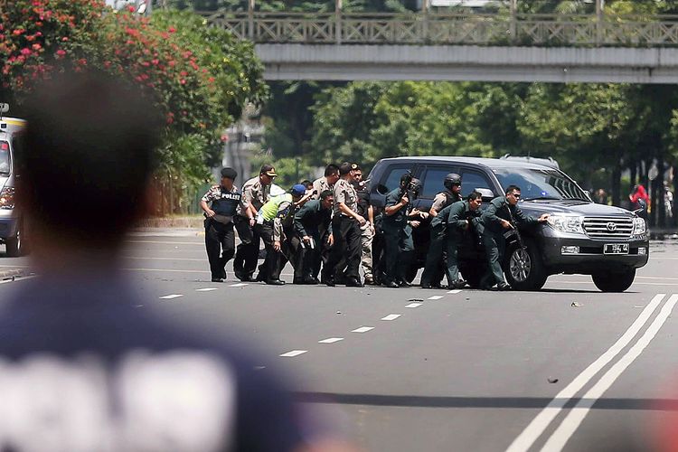 Polisi berlindung dari tembakan teroris saat ledakan bom dan baku tembak di Pos Polisi Sarinah, Jalan MH Thamrin, Jakarta Pusat, Kamis (14/1/2016).