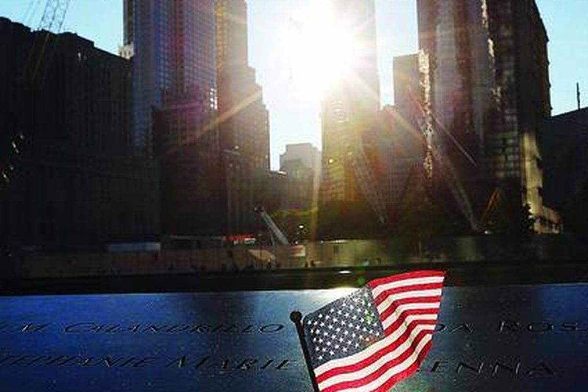Bendera  Amerika Serikat diletakkan di tepi kolam peringatan 9/11 di Ground Zero, Manhattan, New York, sebelum upacara peringatan 11 tahun serangan tersebut, Selasa (11/9). New York dan AS memperingati peristiwa yang menewaskan 2.983 orang tersebut secara sederhana.