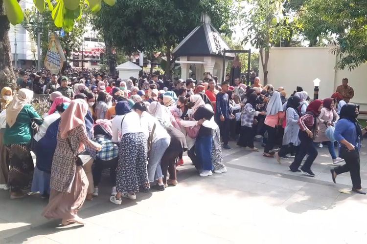 Warga berebut perlengkapan rumah tangga dalam prosesi begalan Kaesang dan Erina di Loji Gandrung Solo, Minggu (11/12/2022).
