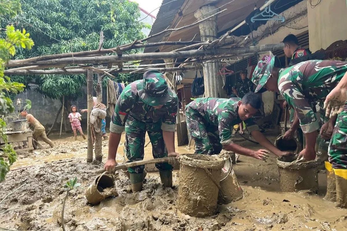 Personel Tentara Nasional Indonesia (TNI) membersihkan lumpur di Pidie Jaya, Aceh.