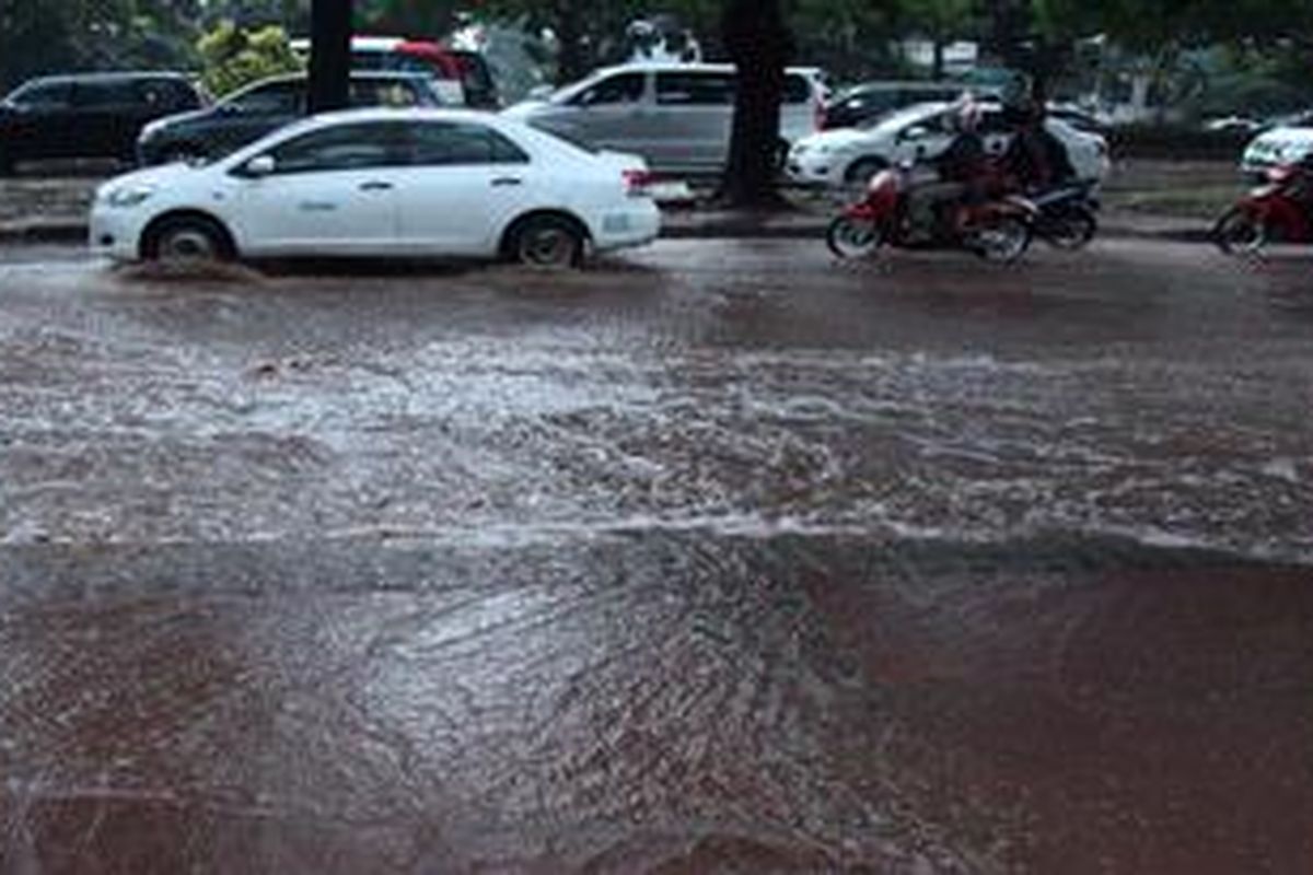 Pengguna jalan melintas di genangan air akibat hujan di Jalan Jenderal Sudirman, Jakarta selatan, Sabtu (27/4/2013). Butuh usaha ektra keras untuk membebaskan Jakarta dari genangan air akibat hujan yang turun.
