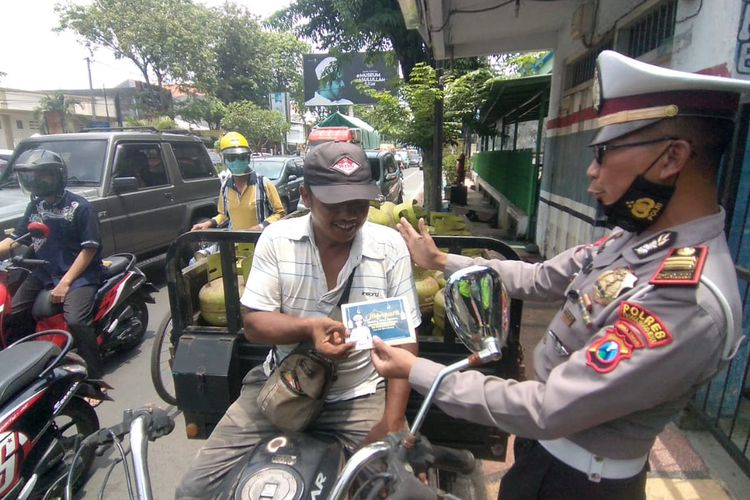 Polisi menegur pengendara tak berhelm dengan memberikan buku saku surat Yasin.