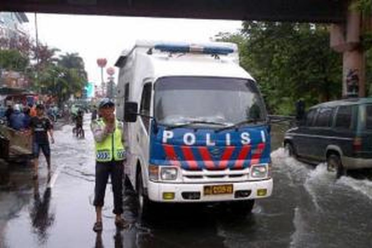 Petugas Penling Jakarta Barat memberikan imbauan kepada masyarakat di sekitar genangan air di depan Citra Land, Selasa (4/2/2014) pagi.