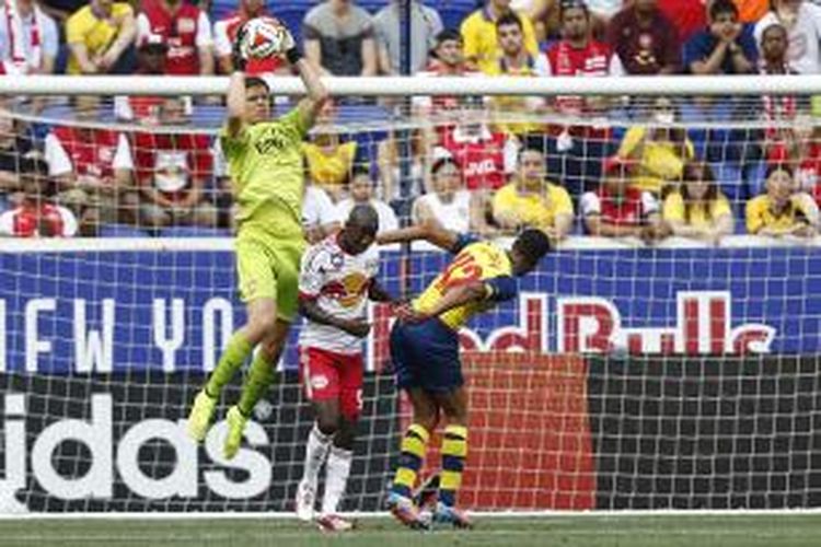 Kiper Arsenal, Wojciech Szczesny, berusaha mengamankan bola dari gangguan pemain New York Red Bulls dalam laga uji coba di Red Bull Arena, Sabtu (26/7/2014).