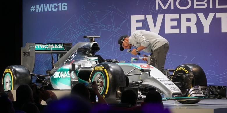 Pembalap F1 Lewis Hamilton menengok mobil dari tim Mercedes yang ikut diboyong ke panggung MWC 2016