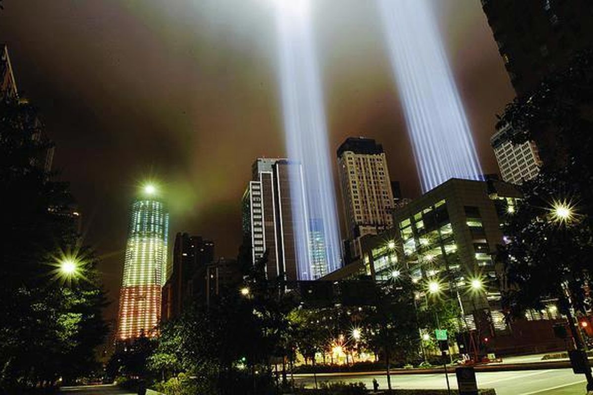 One World Trade Center (kiri), atau yang biasa disebut sebagai 1 WTC di Lower Manhattan, New York, Amerika Serikat,  diterangi oleh lampu berwarna merah, putih, dan biru. Dua pilar lampu menjulang ke angkasa yang disebut sebagai The Tribute in Light tersebut untuk menghormati para korban serangan teroris di menara kembar, New York, 10 tahun silam pada Selasa pagi, 11 September 2001.