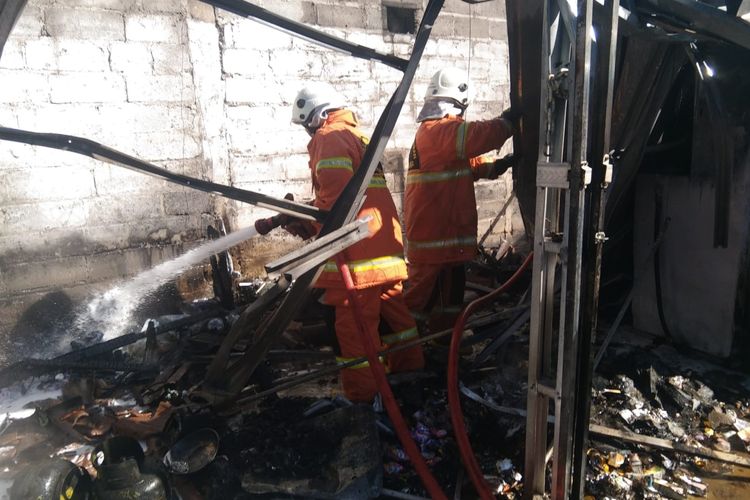 Petugas Damkar Kota Salatiga memadamkan api yang membakar pom mini