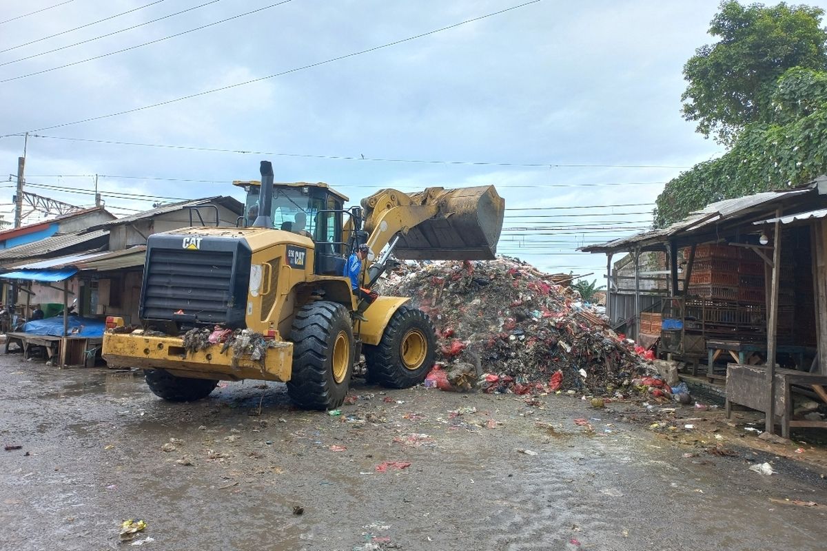 Alat berat jenis beko dikerahkan untuk menangani sampah yang menggunung di tempat oenampungan sampah sementara (TPS) Pasar Kemiri Muka, Beji, Depok pada Selasa (27/12/2022).