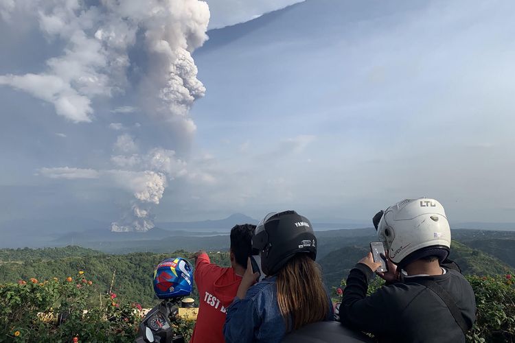 Warga memotret momen Gunung Taal erupsi saat terlihat dari Kota Tagaytay di Provinsi Cavite, Filipina, Minggu (12/1/2020). Gunung berketinggian 311 mdpl ini statusnya juga telah meningkat ke level 4 yang berarti status bahaya.
