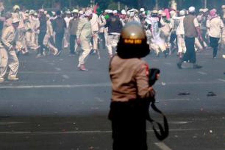 Polisi menghadapi massa Front Pembela Islam (FPI) yang melemparkan batu ke arah Gedung DPRD DKI Jakarta saat terjadi kerusuhan menyusul aksi unjuk rasa FPI, Jumat (3/10/2014). Massa FPI berdemo menolak Ahok diangkat menjadi Gubernur DKI Jakarta.