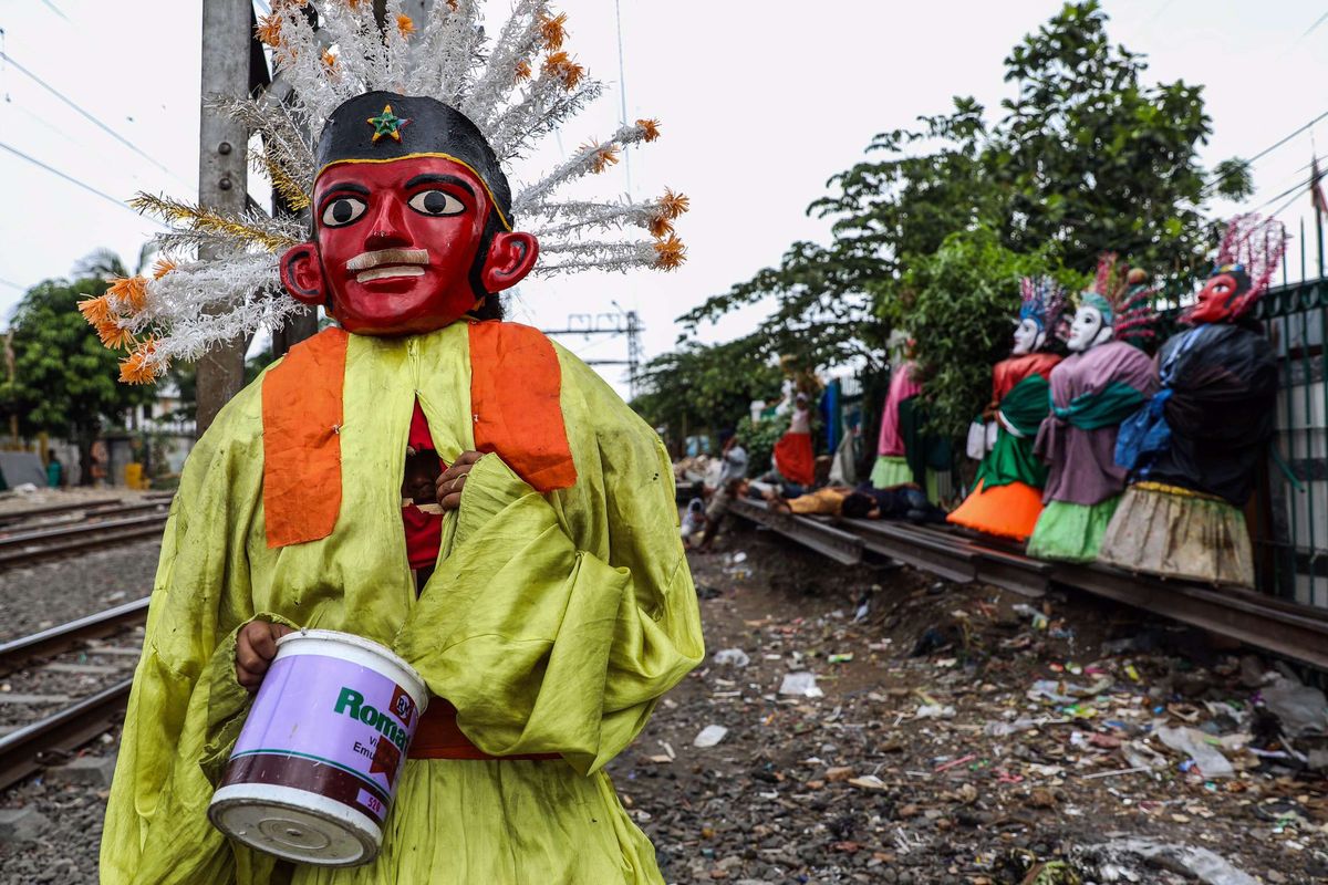 Pengrajin saat memakai boneka ondel-ondel di Jalan Kembang Pacar, Senen, Jakarta Pusat, Rabu (2/9/2020). Pandemi Covid-19 dianggap menjadi tantangan terberat bagi para pengrajin ondel-ondel di Kramat Pulo setelah bertahan hidup di ibukota lebih dari lima dekade.