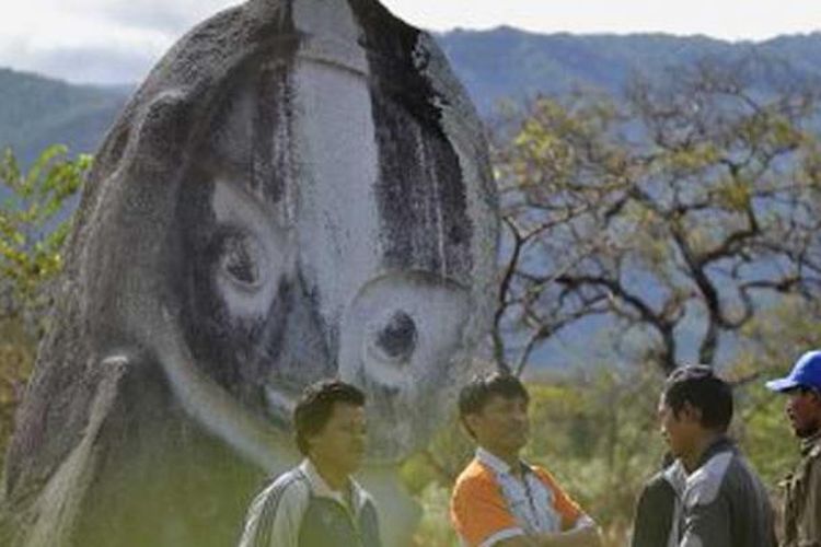 Lelaki suku Lore subetnis To Bada berbincang di depan arca menhir Palindo di Lembah Bada, tepatnya di Padang Sepe, Desa Bewa, Kecamatan Lore Selatan, Kabupaten Poso, Sulawesi Tengah, Jumat (30/8/2013), dalam kegiatan Ekspedisi Budaya Lembah Bada. Palindo adalah arca megalitik terbesar yang ada di Lembah Bada. 