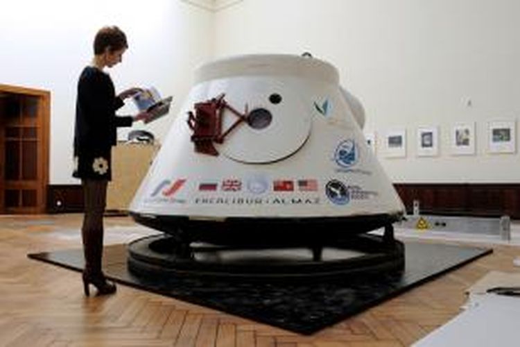 Seorang perempuan tengah mengamati sebuah kapsul angkasa luar era 1970-an buatan Uni Soviet yang akan dilelang bulan depan. Rumah lelang Lempertz berharap kapsul ini akan terjual dengan harga setidaknya Rp 22,5 miliar.