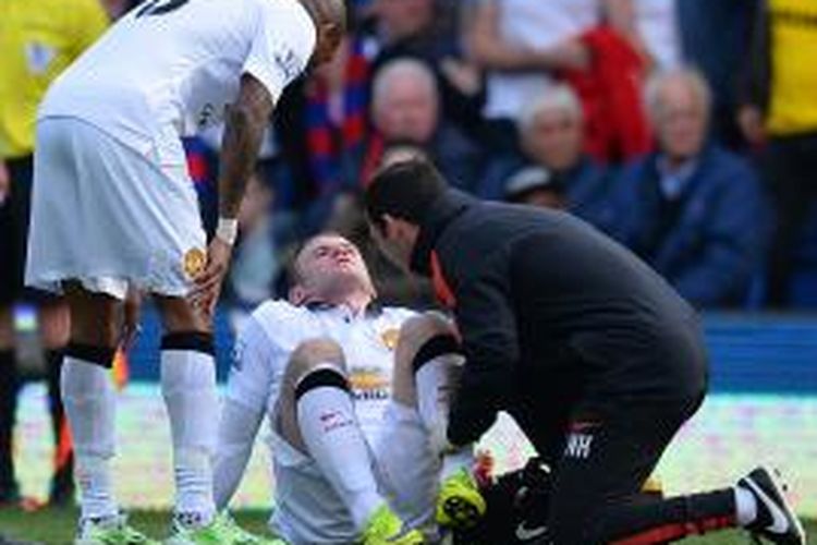 Penyerang Manchester United Wayne Rooney (kedua dari kanan) mendapatkan perawatan medis setelah mengalami masalah mati rasa pada kaki, ketika tampil pada laga Premier League, di Selhurst Park, London, 9 Mei 2015. 