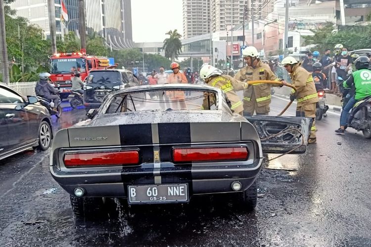 Pemadam kebakaran sedang memadamkan api pada sebuah mobil Ford Mustang 1966 di Pondok Indah, Senin (26/7/2021). Dok: Petugas Damkar Kebayoran Lama