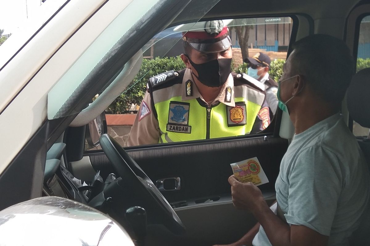 Seorang petugas tengah menanyakan tujuan kepada seorang pengendara di titik check point di Kedungwaringin, Kabupaten Bekasi, Minggu (26/4/2020). Mereka yang kedapatan hendak mudik diminta memutar balik sebelum memasuki Kabupaten Karawang.