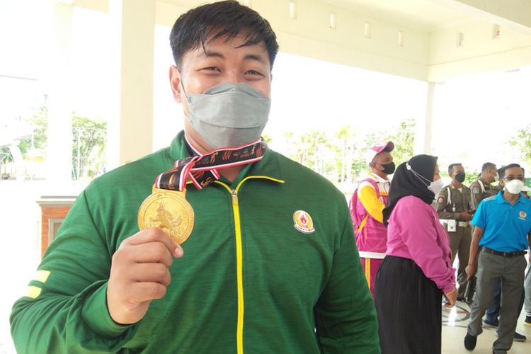 Dimas Septo Anugraha menunjukkan medali emas, yang diraih dari cabor gulat gaya bebas kelas 125 kilogram pada PON XX di Papua.