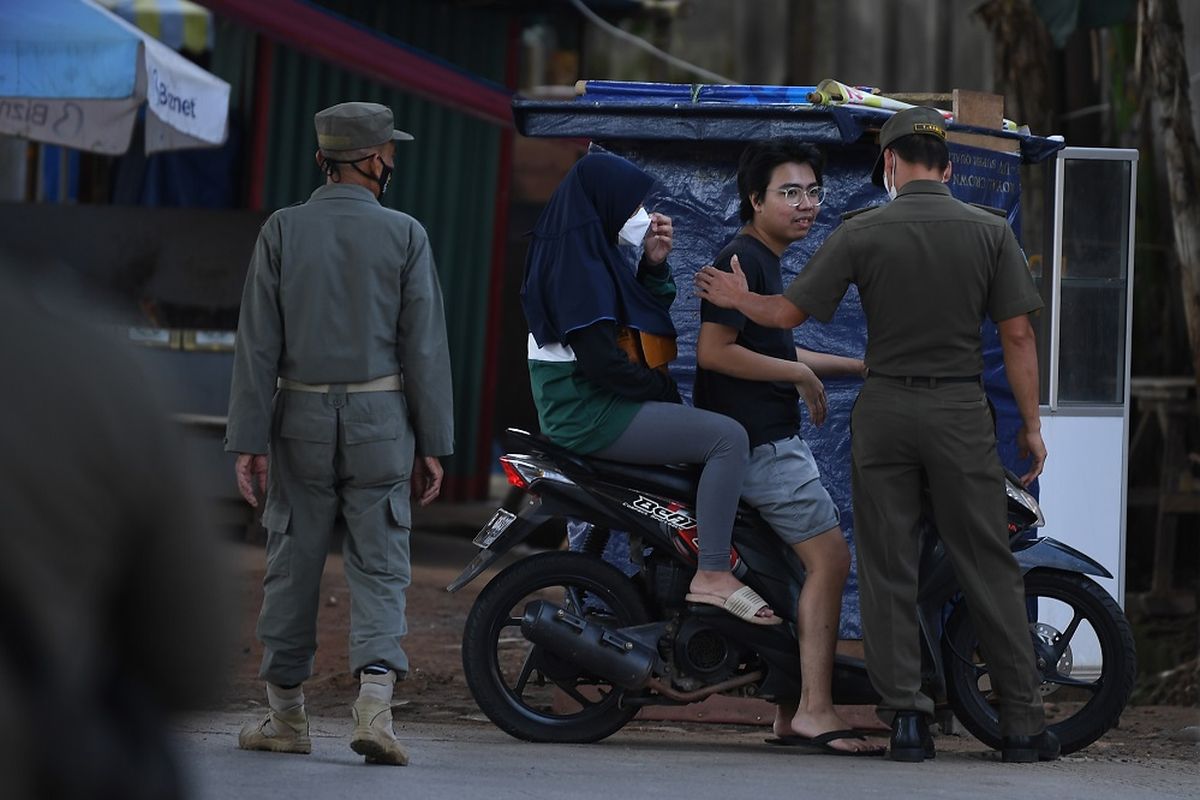 Anggota Satpol PP Kecamatan Cilandak menegur pengendara motor yang tidak memakai masker saat razia protokol kesehatan PPKM level 2 di Pondok Labu, Jakarta, Selasa (5/4/2022). ANTARA FOTO/Sigid Kurniawan/rwa.