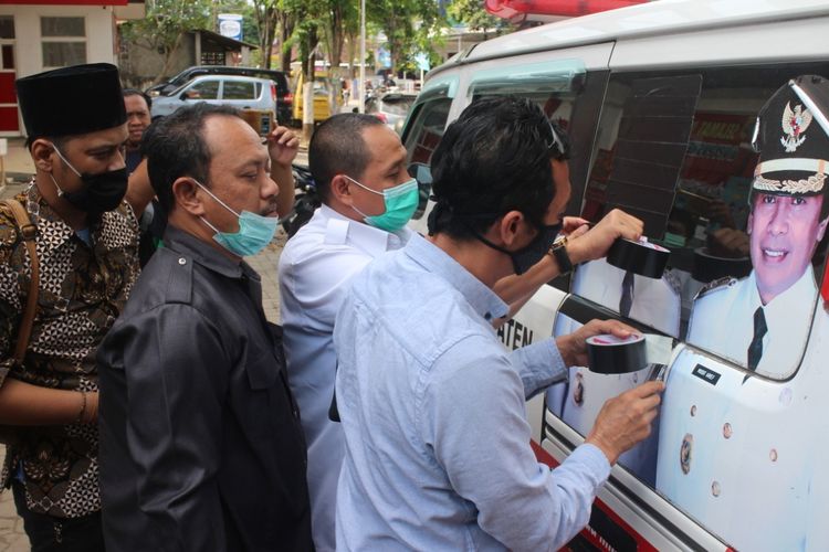 Bawaslu bersama Pansus Pilkada DPRD Jember saat menutup gambar pertahana di mobil ambulan Puskesmas Mangli 