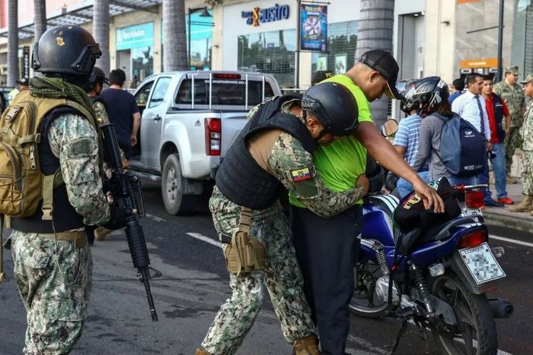 Pasukan keamanan Ekuador menggeledah seorang pria yang dilarang saat mengendarai sepeda motor di Guayaquil pada 3 April 2023.