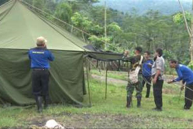 Petugas dari Tagana,Polisi juga TNI mendirikan tenda pengungsian bagi warga terdampak longsor di desa Depok Kecamatan Bendungan Trenggalek Jawa timur (25/11/2016).