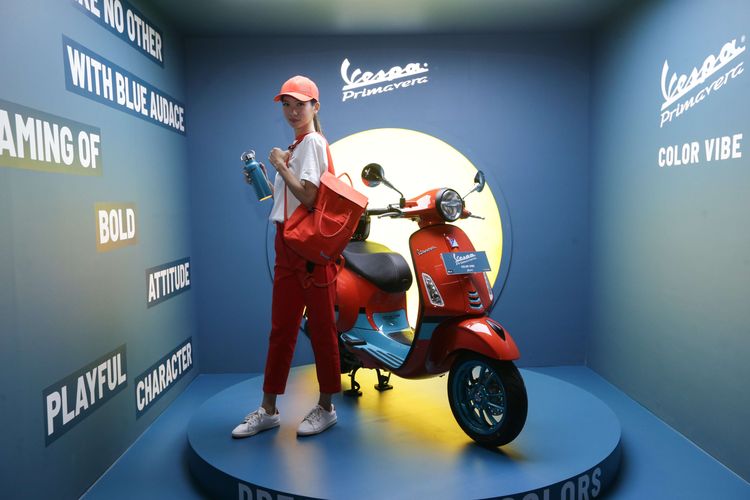 Model memperlihatkan merchandise edisi Vespa Primavera Color Vibe saat peluncuran di Jakarta, Selasa (4/4/2023).  Vespa Primavera Color Vibe hadir dalam dua pilihan warna yaitu orange tramonto dan blue audace.