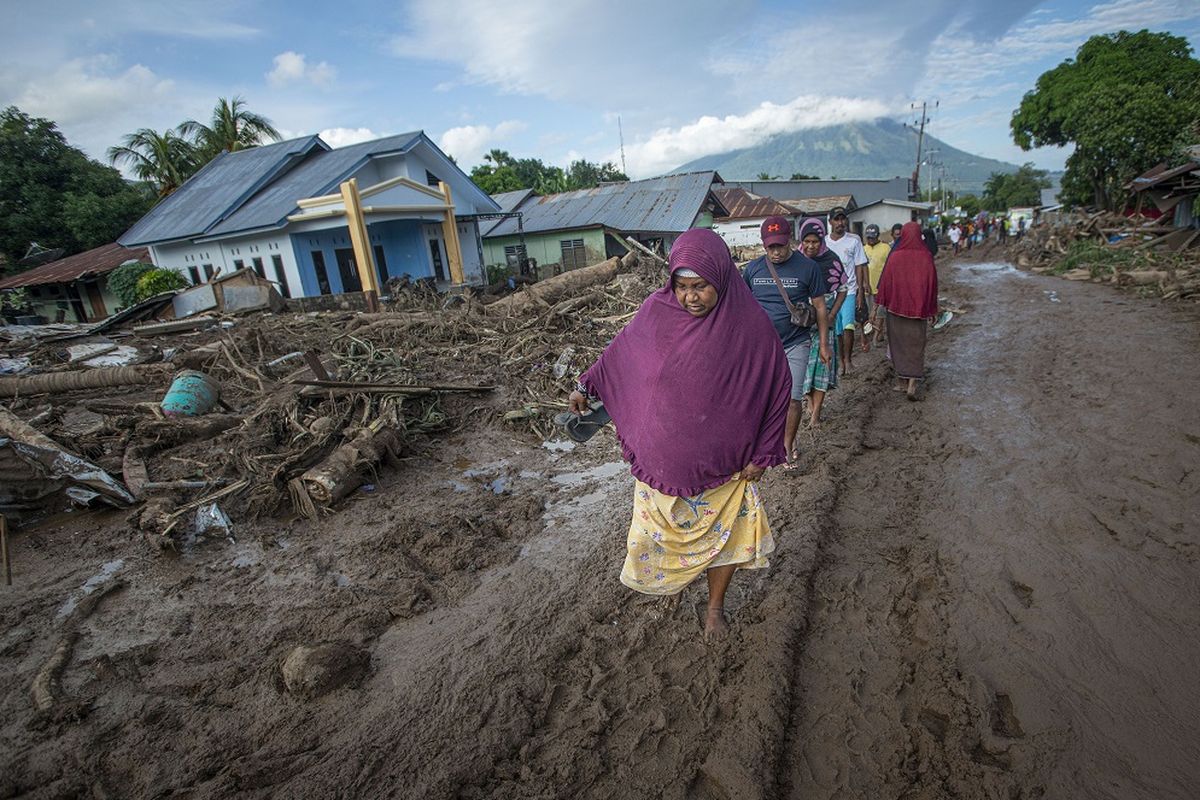 Sejumlah warga berusaha melewati jalan yang tertutup lumpur akibat banjir bandang di Adonara Timur, Kabupaten Flores Timur, Nusa Tenggara Timur (NTT), Selasa (6/4/2021). Cuaca ekstrem akibat siklon tropis Seroja telah memicu bencana alam di sejumlah wilayah di NTT dan mengakibatkan rusaknya ribuan rumah warga dan fasilitas umum. ANTARA FOTO/Aditya Pradana Putra/wsj.