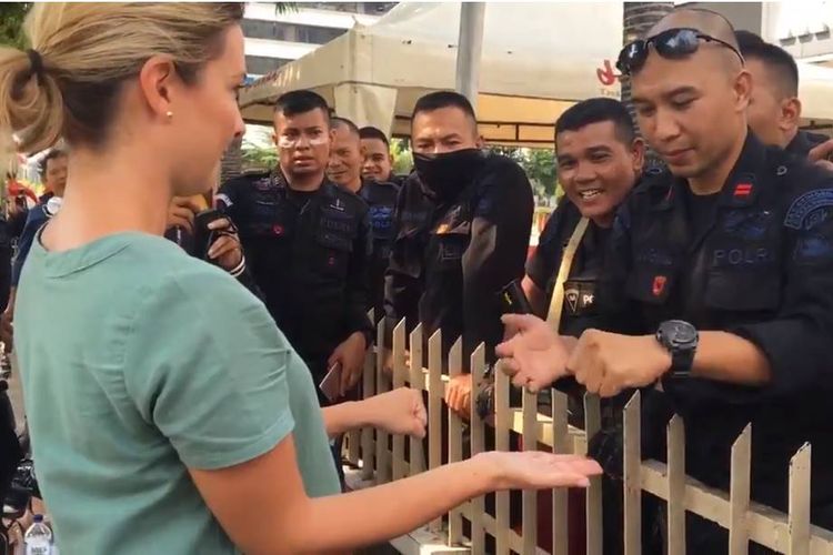 Ridho Vernando, anggota Brimob berpangkat Bharatu asal Padang, Sumatera Barat, (kanan) sedang menunjukkan kelihaiannya dalam sulap di depan jurnalis asal Australia, Renea Henry. Aksi menghibur ini dilakukannya di sela bertugas pada aksi 22 Mei di Jakarta.