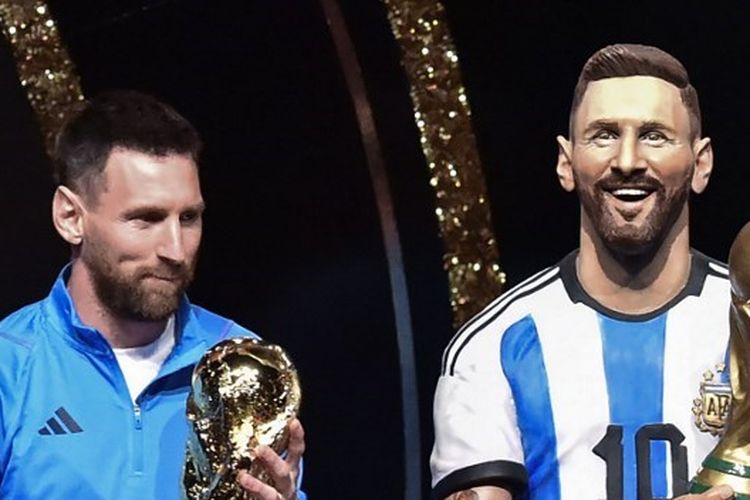 Lionel Messi berdiri di samping patung dirinya dalam agenda penghormatan dari Conmebol usai Argentina juara Piala Dunia 2022. Acara ini bergulir di markas Conmebol, Luque, Paraguay Senin (27/3/2023). (Foto oleh NORBERTO DUARTE / AFP)