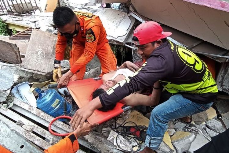 Petugas mengevakuasi korban yang terjepit bangunan di rumah sakit Mitra Manakarra yang runtuh akibat gempa bumi di Mamuju, Sulawesi Barat, Kamis (15/1/2021).